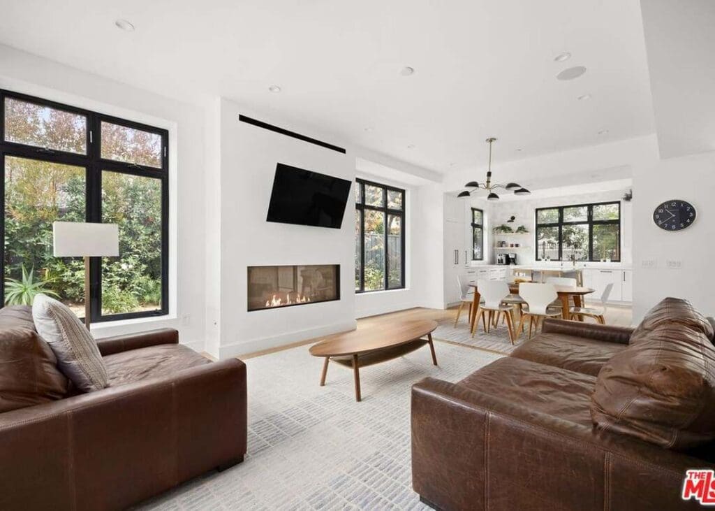 A living room with couches, tables and a fireplace.
