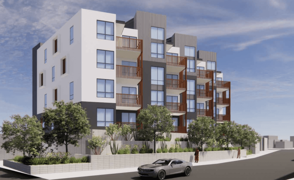 Modern apartment building with trees and car.